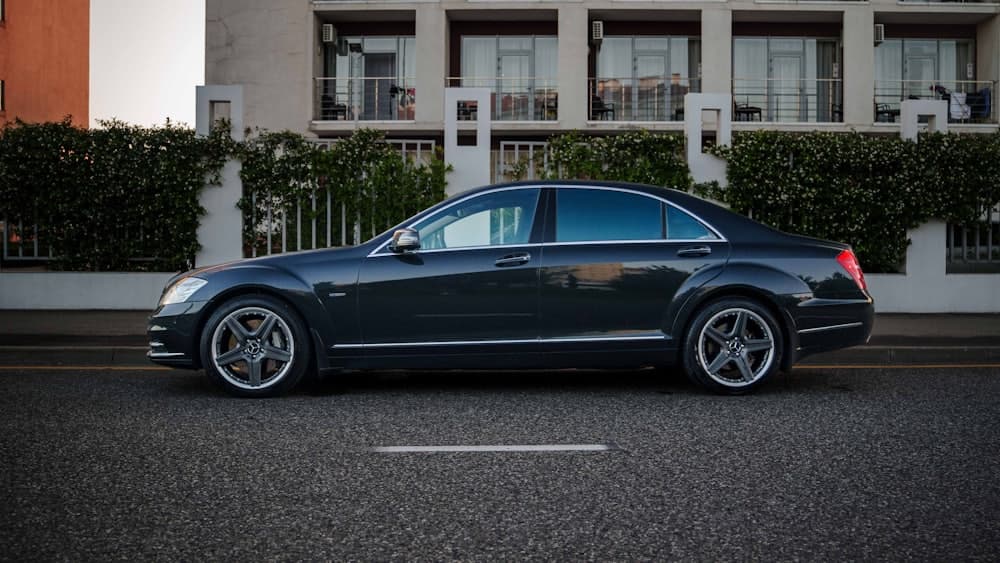 A dark grey luxury saloon parked on a city street