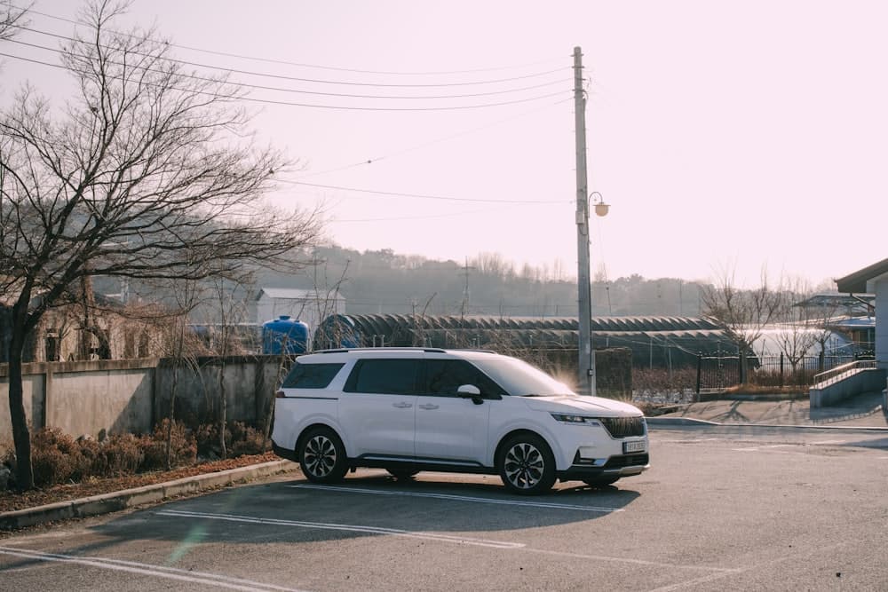 A white seven-seat people carrier parked in an empty car park