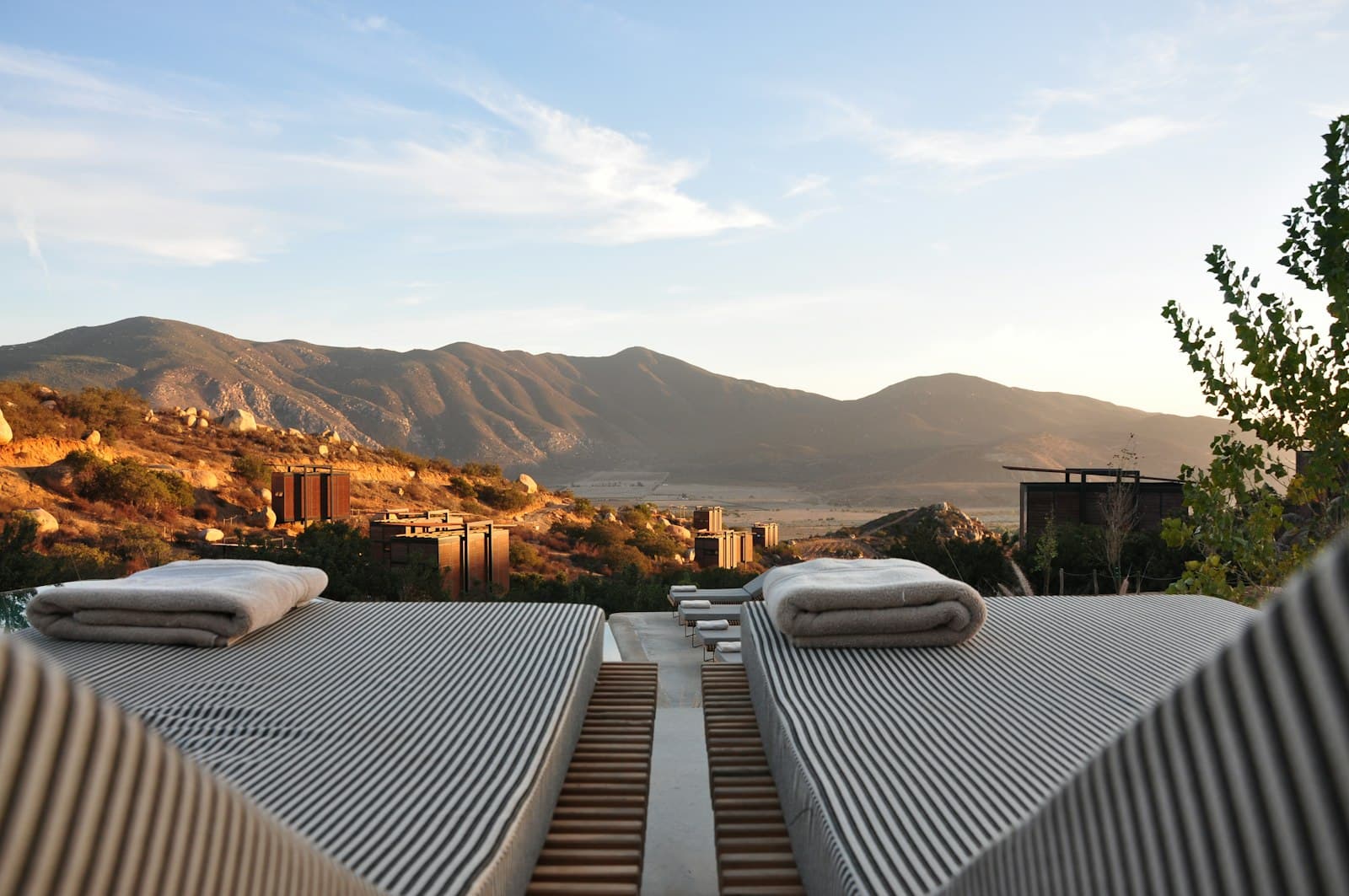 Sun loungers on a hillside retreat terrace looking out over a mountain valley